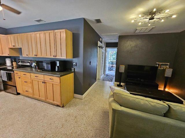 kitchen featuring dark countertops, visible vents, ceiling fan, and electric range