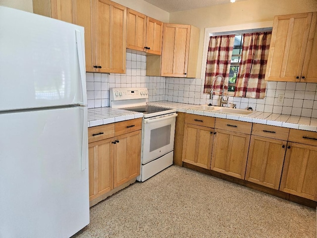 kitchen with tile countertops, decorative backsplash, light brown cabinets, a sink, and white appliances