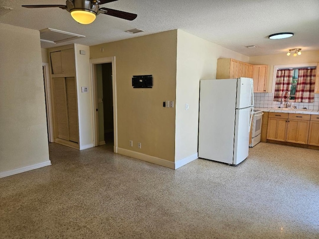 kitchen with white appliances, decorative backsplash, a textured ceiling, light speckled floor, and a sink