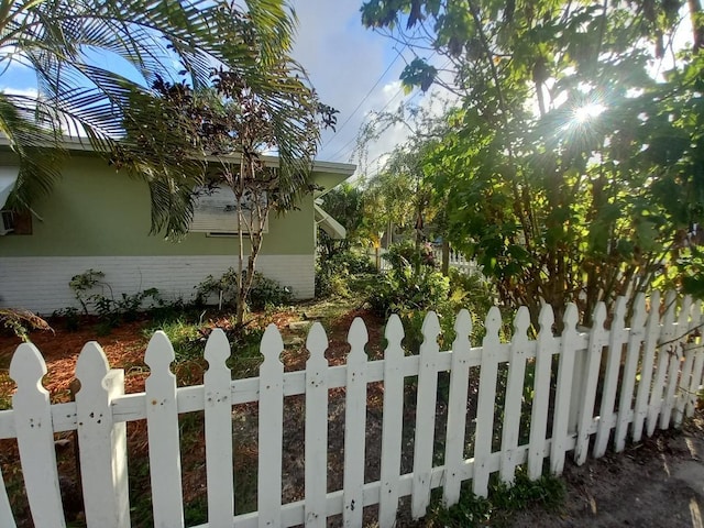 view of side of property featuring a fenced front yard and brick siding