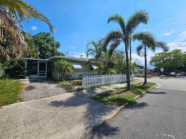 view of front of property with a fenced front yard and a sunroom