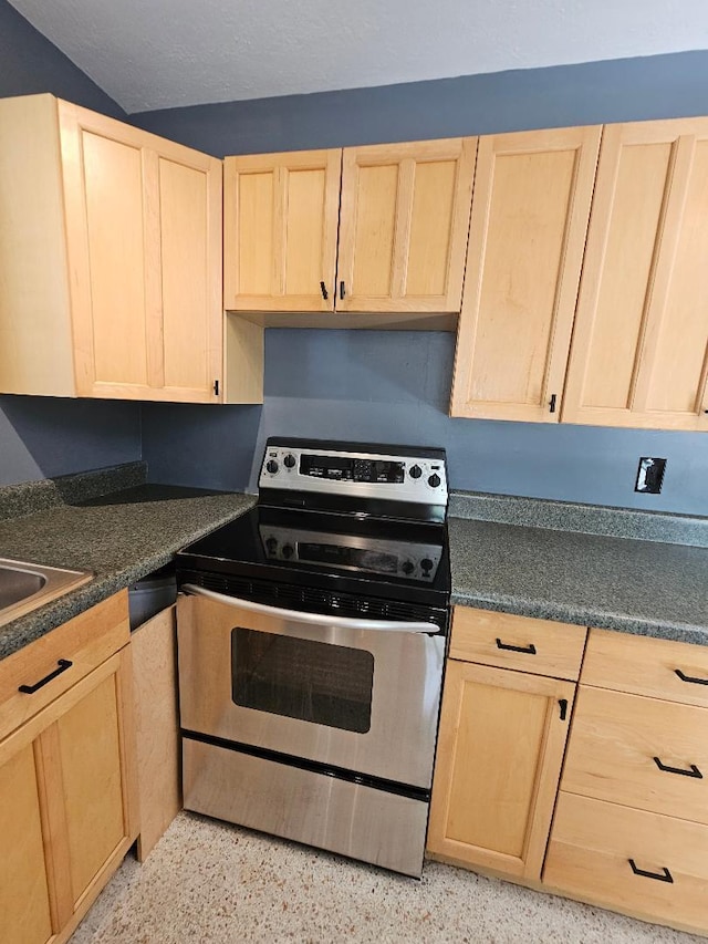 kitchen with light speckled floor, dark countertops, light brown cabinets, and stainless steel electric range oven