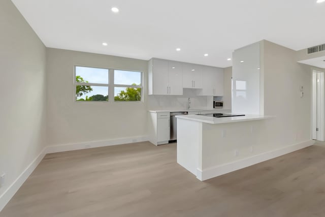 kitchen featuring stainless steel appliances, visible vents, light countertops, and light wood finished floors