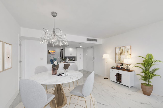 dining area featuring marble finish floor, visible vents, and a notable chandelier