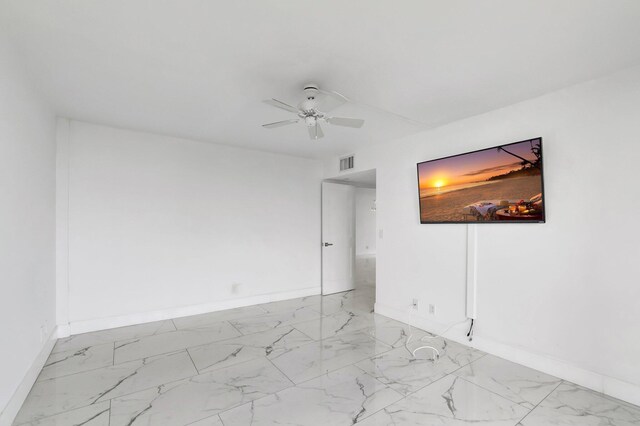 unfurnished room featuring marble finish floor, baseboards, visible vents, and ceiling fan