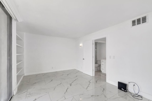 spare room featuring marble finish floor, visible vents, and baseboards