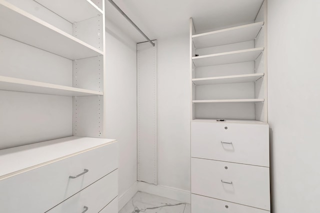 spacious closet featuring marble finish floor