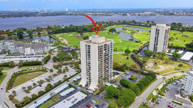 birds eye view of property with view of golf course and a water view