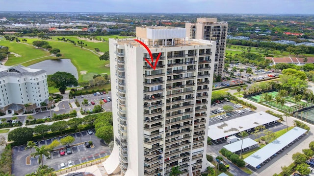 birds eye view of property featuring view of golf course, a water view, and a city view