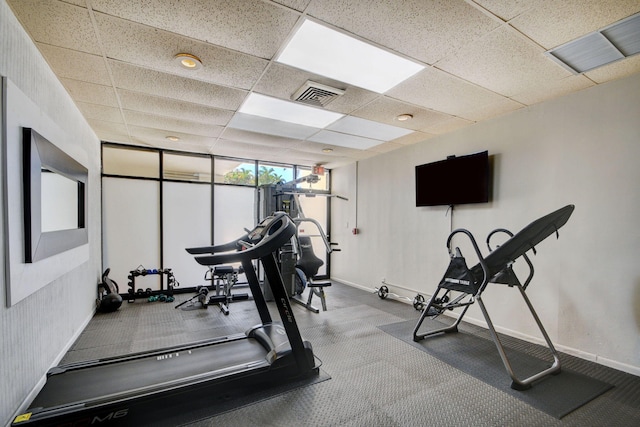 workout area with a drop ceiling, visible vents, and baseboards