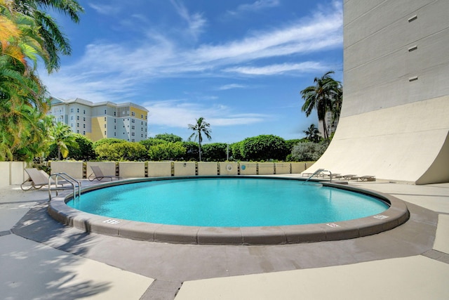 community pool with fence and a patio