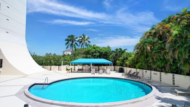 community pool featuring a patio and fence