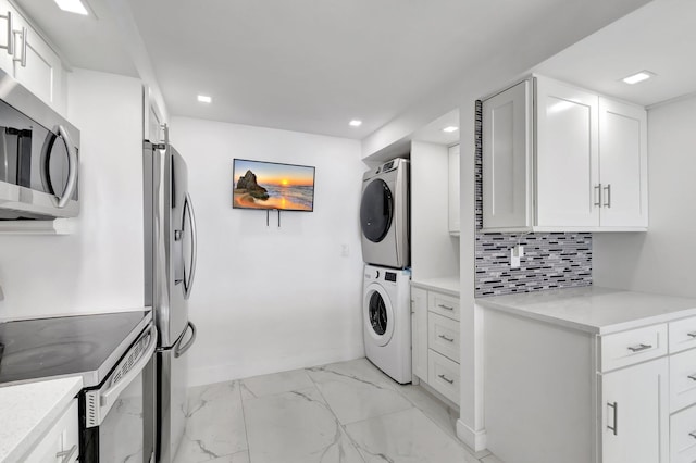 kitchen featuring tasteful backsplash, stacked washer / drying machine, marble finish floor, stainless steel appliances, and white cabinetry