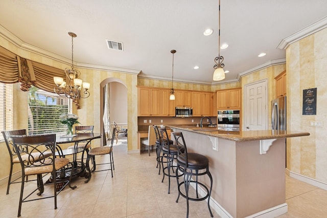 kitchen with visible vents, ornamental molding, a sink, arched walkways, and appliances with stainless steel finishes