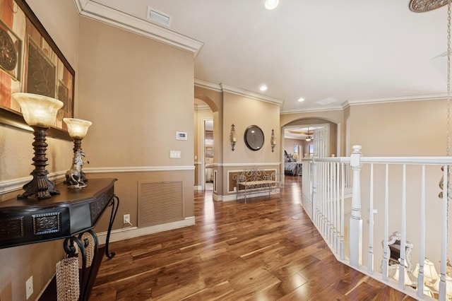 corridor featuring arched walkways, visible vents, and wood finished floors