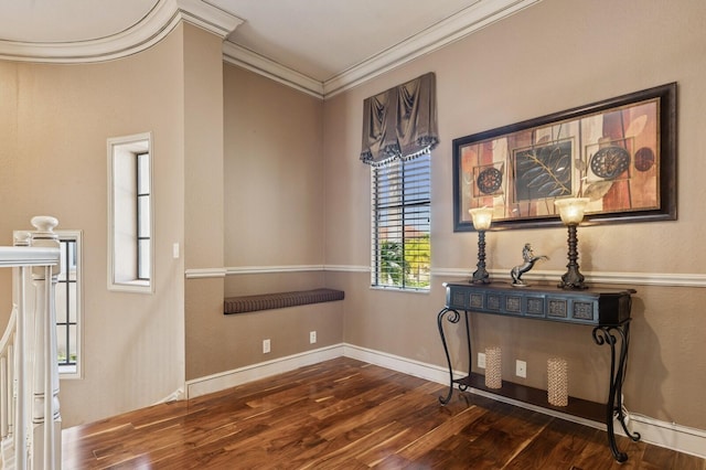 interior space featuring ornamental molding, baseboards, and wood finished floors