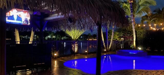 pool at twilight with a fenced in pool and fence