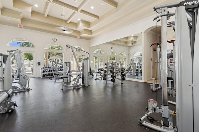 gym with visible vents, coffered ceiling, recessed lighting, a high ceiling, and crown molding