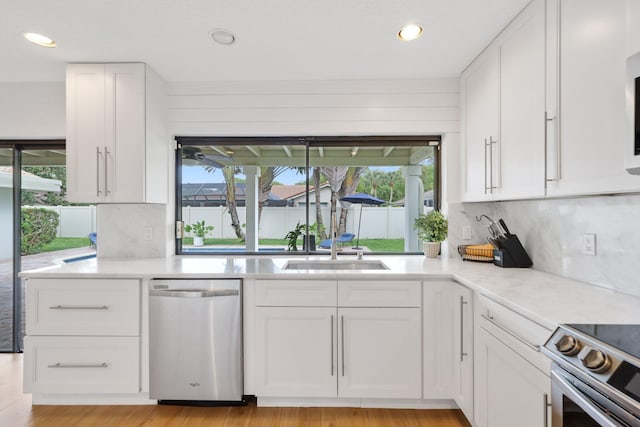 kitchen featuring stainless steel appliances, white cabinetry, and a sink