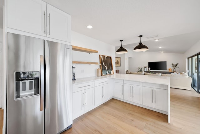 kitchen featuring a peninsula, white cabinets, open floor plan, and stainless steel fridge with ice dispenser