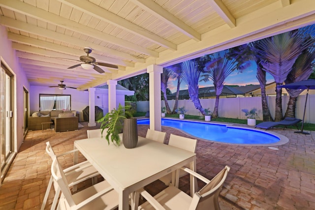 pool at dusk featuring area for grilling, a fenced backyard, an outdoor hangout area, outdoor dining area, and a patio area