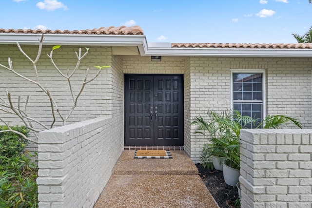 entrance to property featuring a tile roof