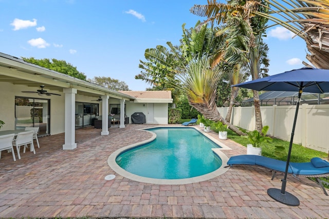 view of swimming pool with ceiling fan, a patio area, a fenced backyard, and a fenced in pool