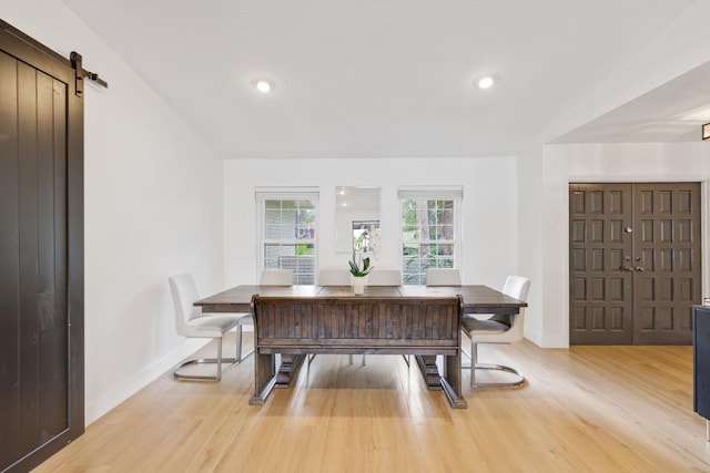 dining space featuring light wood-style floors, a barn door, baseboards, and recessed lighting