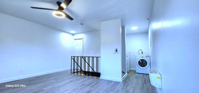 clothes washing area with ceiling fan, laundry area, wood finished floors, baseboards, and washer and clothes dryer