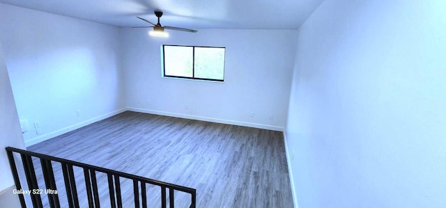 spare room with ceiling fan, wood finished floors, and baseboards