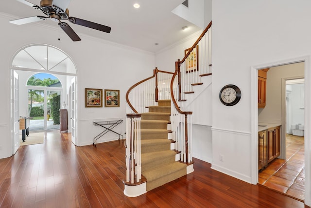 foyer with crown molding, baseboards, and wood finished floors