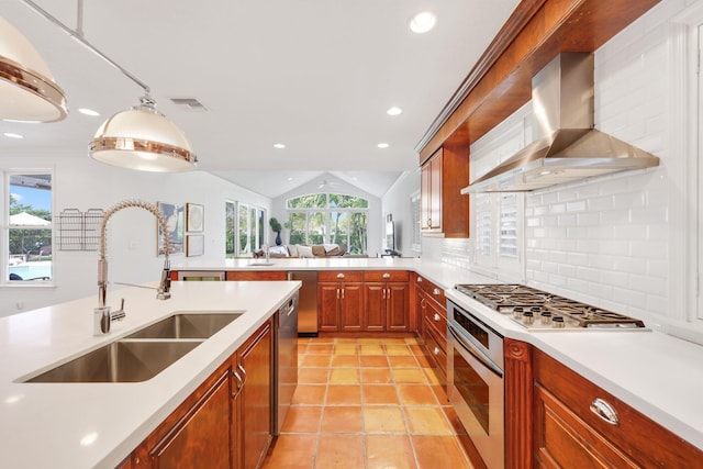 kitchen with tasteful backsplash, visible vents, appliances with stainless steel finishes, wall chimney range hood, and a sink