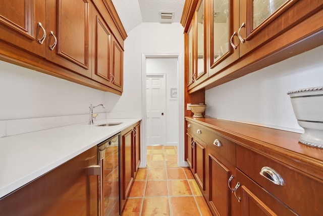 bar featuring lofted ceiling, visible vents, a sink, a textured ceiling, and beverage cooler