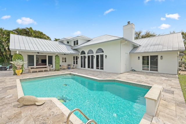 rear view of property featuring a standing seam roof, a patio area, metal roof, ceiling fan, and an outdoor living space