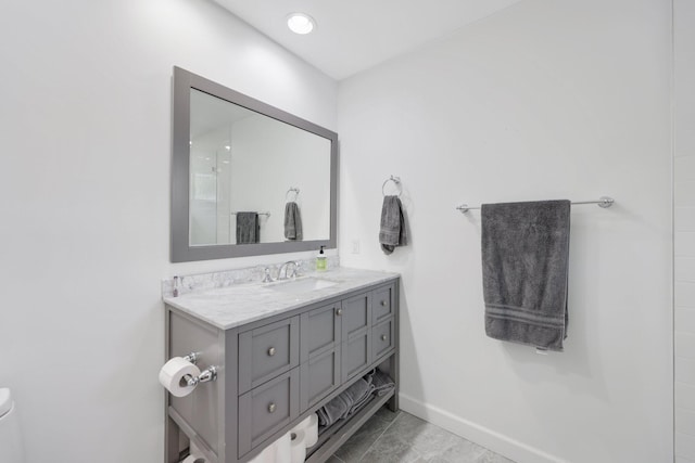 full bathroom featuring toilet, vanity, baseboards, and tile patterned floors