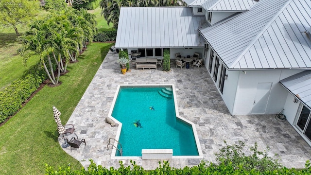 outdoor pool with a patio area and a yard