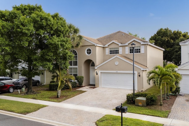 view of front of property with decorative driveway, a tiled roof, and stucco siding