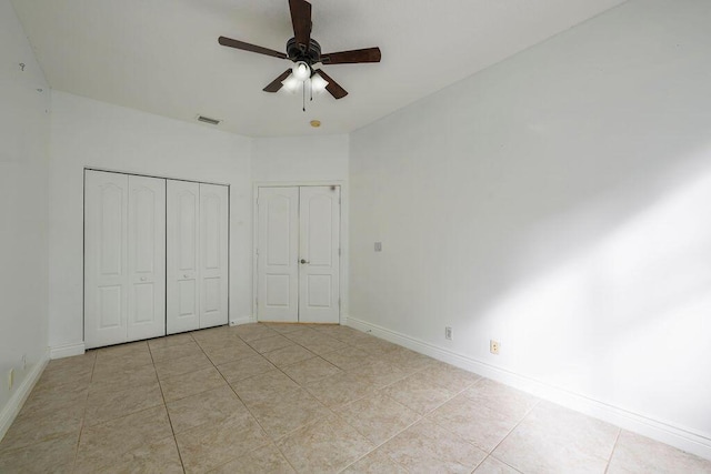 unfurnished bedroom featuring a closet, visible vents, baseboards, and light tile patterned floors