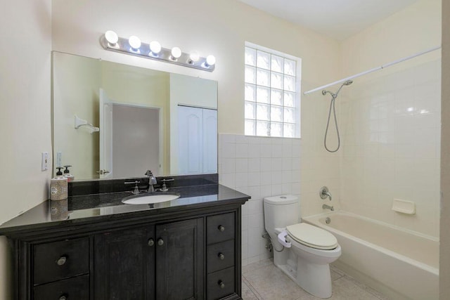 full bath with tile walls, shower / bathtub combination, toilet, vanity, and tile patterned floors