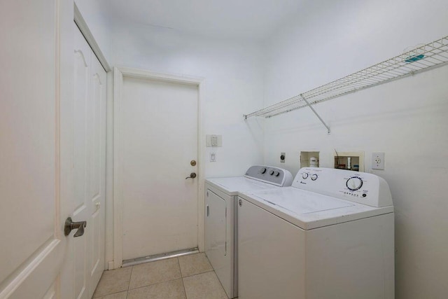 laundry area featuring laundry area, washing machine and clothes dryer, and light tile patterned floors