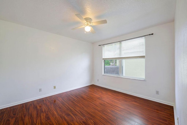 spare room featuring ceiling fan, a textured ceiling, baseboards, and wood finished floors