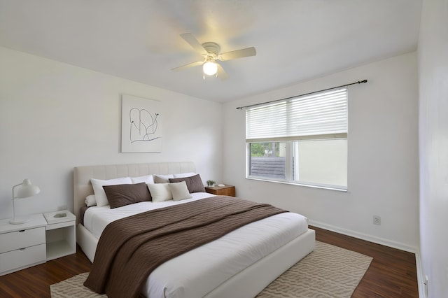 bedroom with ceiling fan, dark wood-type flooring, and baseboards