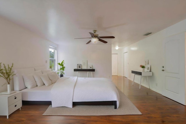 bedroom featuring baseboards, visible vents, ceiling fan, and wood finished floors