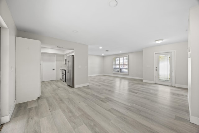 unfurnished living room featuring baseboards, light wood-style flooring, and recessed lighting