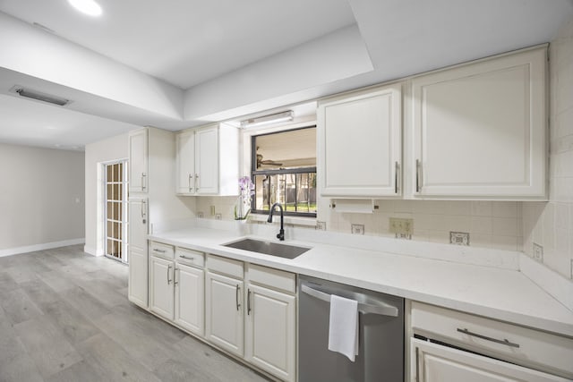 kitchen with visible vents, decorative backsplash, dishwasher, light wood-style floors, and a sink