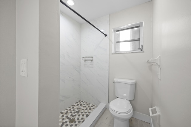 bathroom featuring baseboards, a shower stall, and toilet