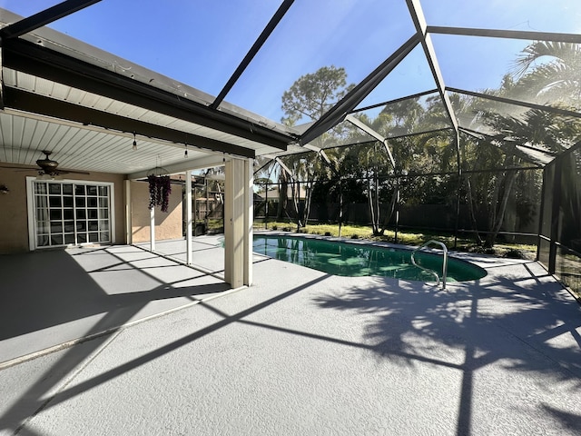 outdoor pool with ceiling fan, glass enclosure, and a patio area