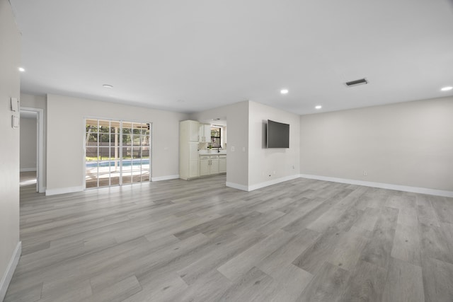 unfurnished living room featuring baseboards, recessed lighting, visible vents, and light wood-style floors