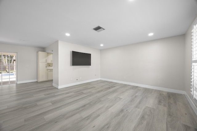 unfurnished living room with recessed lighting, light wood-type flooring, visible vents, and baseboards