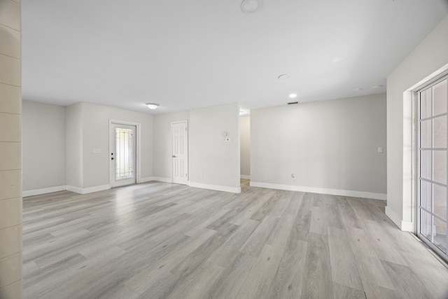 unfurnished room featuring light wood finished floors and baseboards